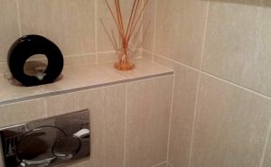 Pose de carrelage sur murs dans des toilettes
