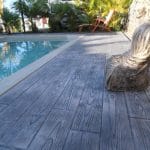 Béton imprimé bois en latte de 15 cm proche d'une piscine