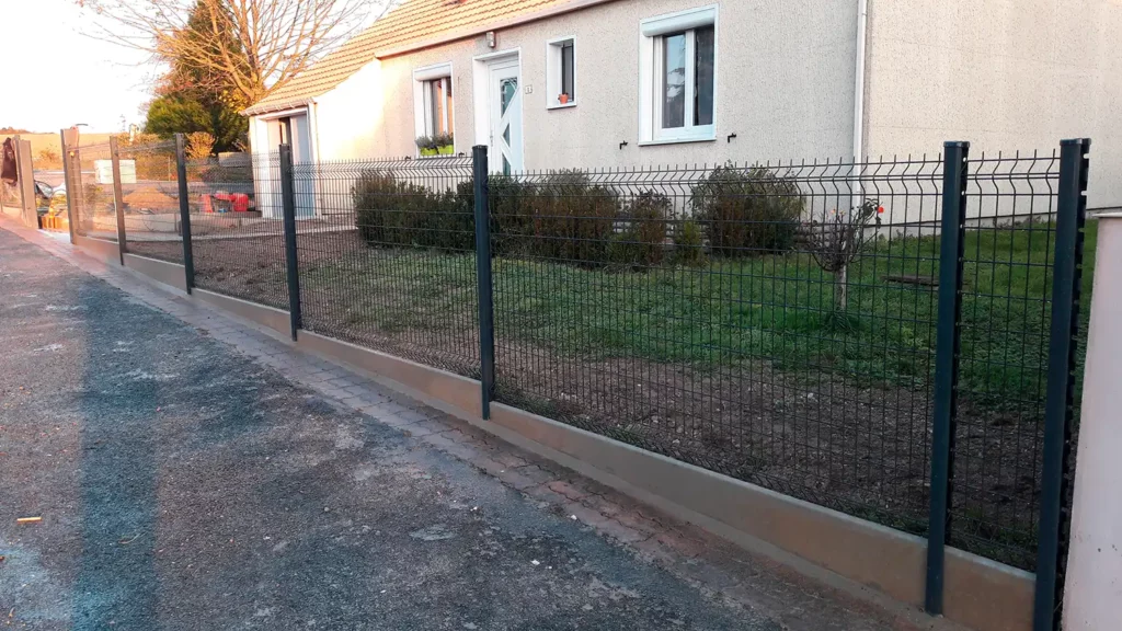 Clôture grillagée posée sur un muret béton
