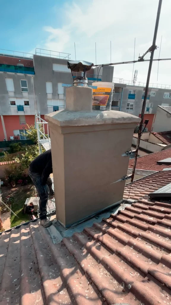 Souche de cheminée enduite sur toiture en tuiles