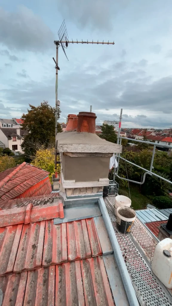 Souche de cheminée et antenne sur toiture en tuiles