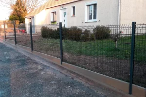 Clôture grillagée posée sur un muret béton