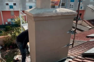 Souche de cheminée enduite sur toiture en tuiles