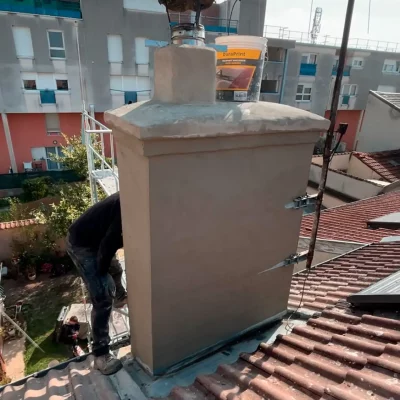 Souche de cheminée enduite sur toiture en tuiles