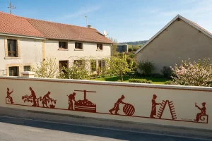 Mur de façade avec enduit décoratif contrasté sur le thème viticole